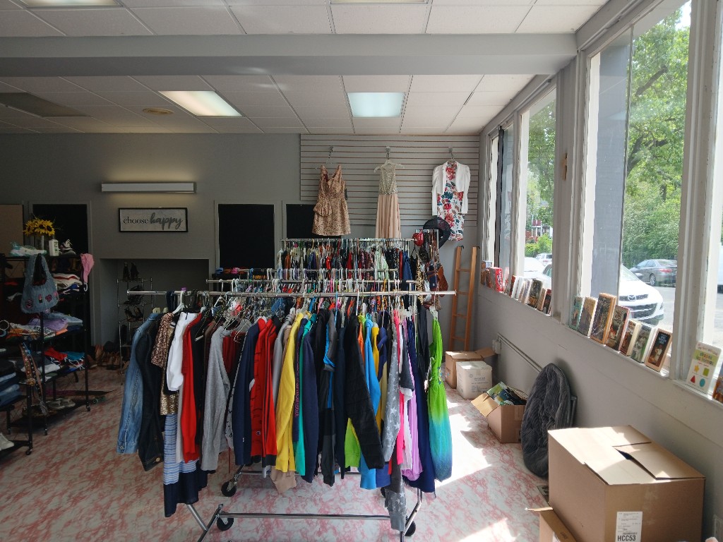 Wide view of community clothing closet racks and browsing area